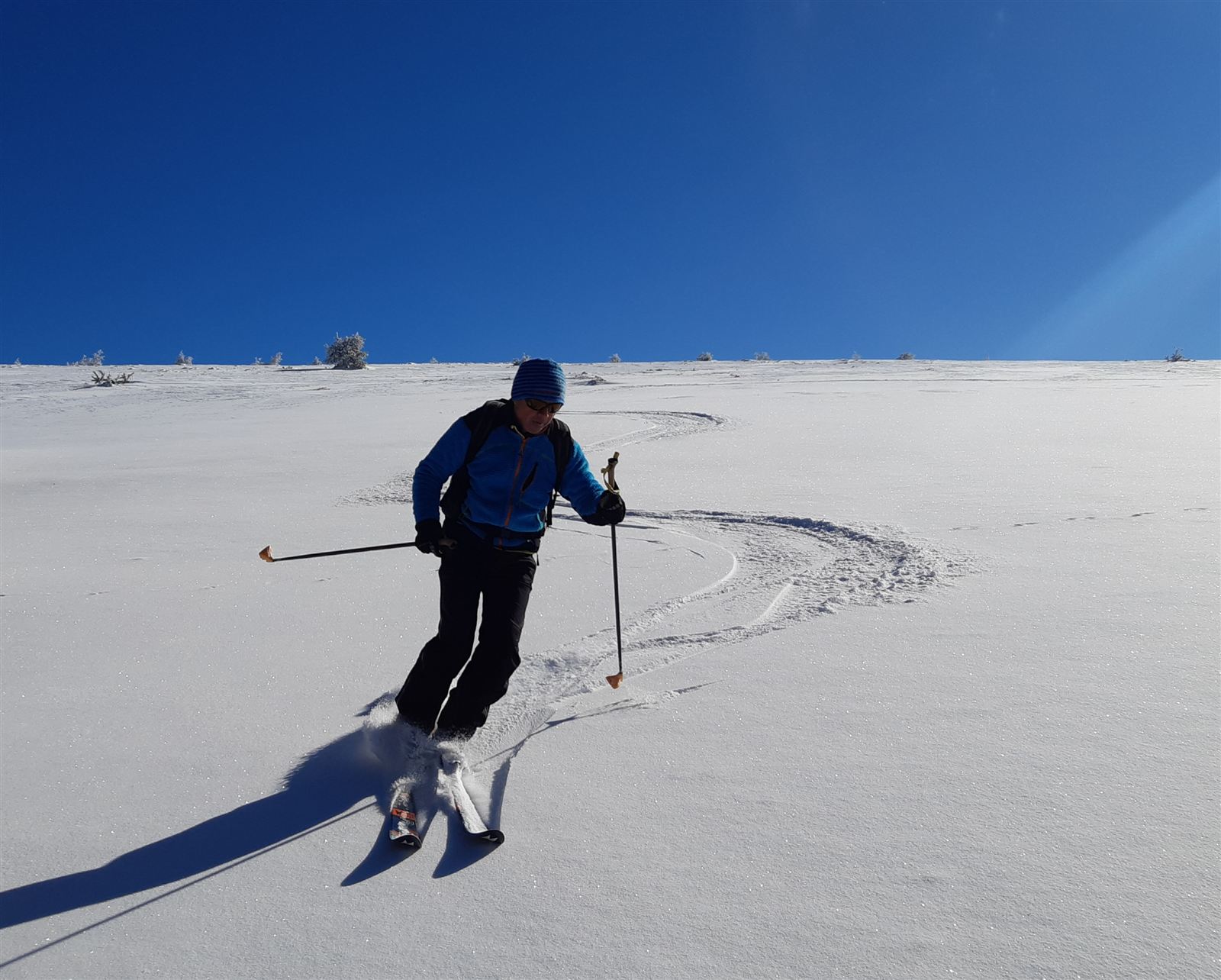 Skieur de fond traçant sa piste en forêt